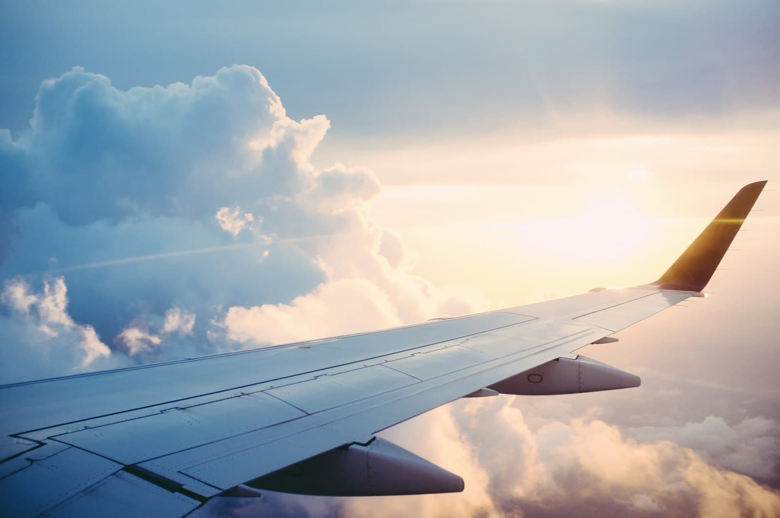 View of an aeroplane wing above the clouds at sunset
