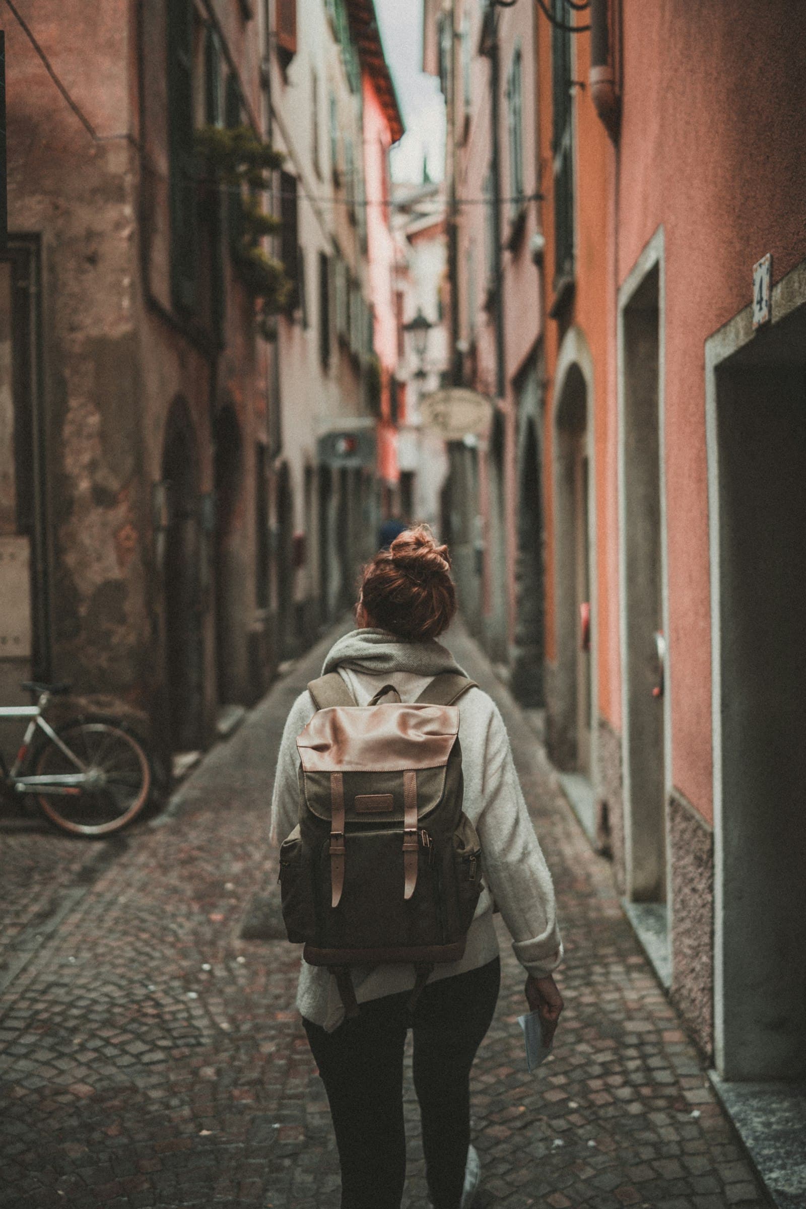 A solo traveller with a backpack exploring a narrow old-town street