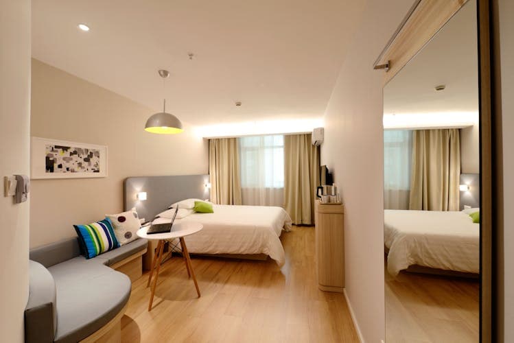 Clean modern hotel room with twin beds — choosing the right accommodation for a group