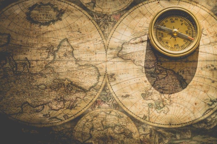 Antique world map with compass — planning the perfect group itinerary