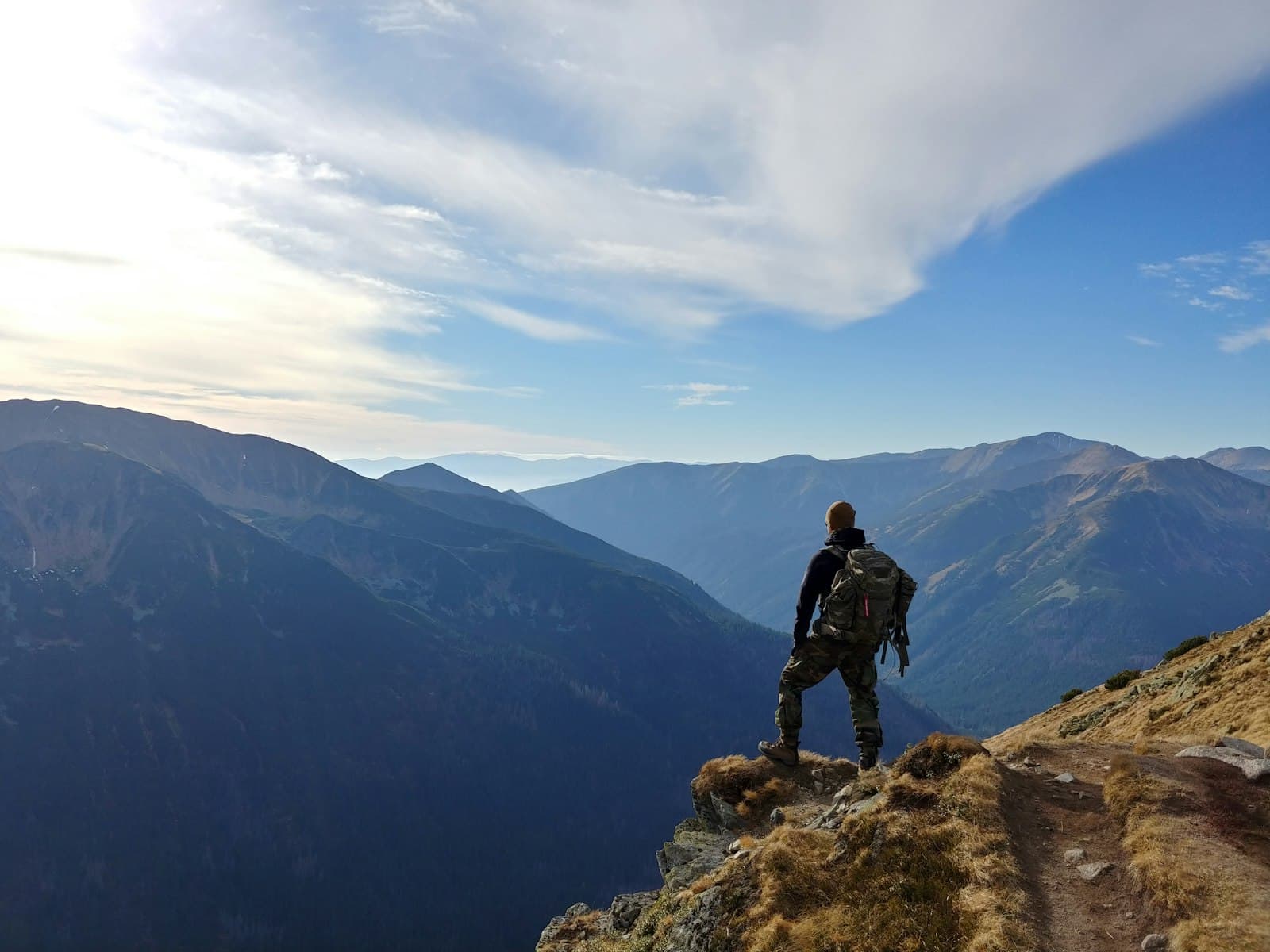A hiker looking out over a mountain range while travelling