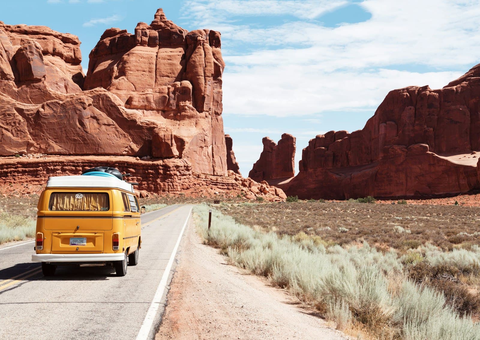 A camper van on an open desert road, taking a trip